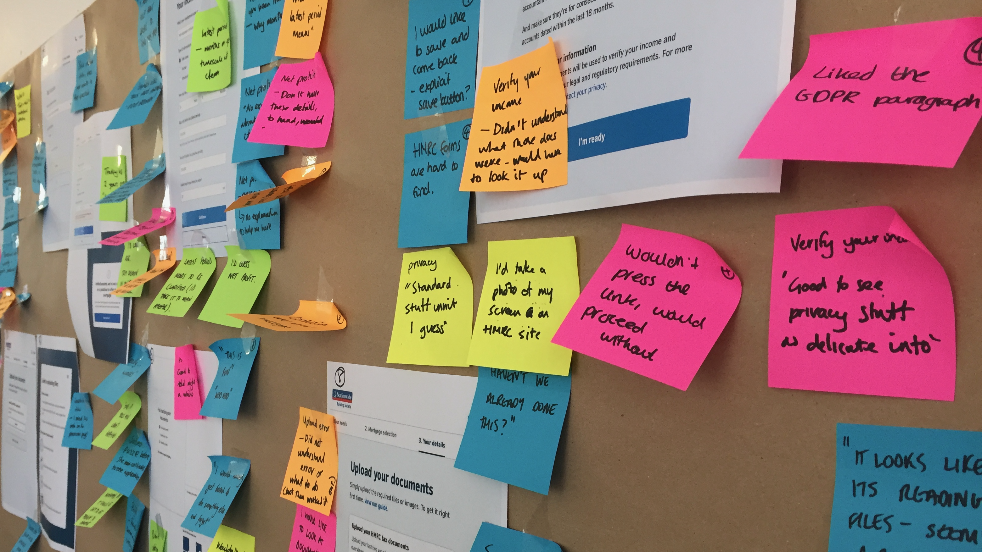Printed mortgage prototype screens covered with sticky-note feedback and questions.